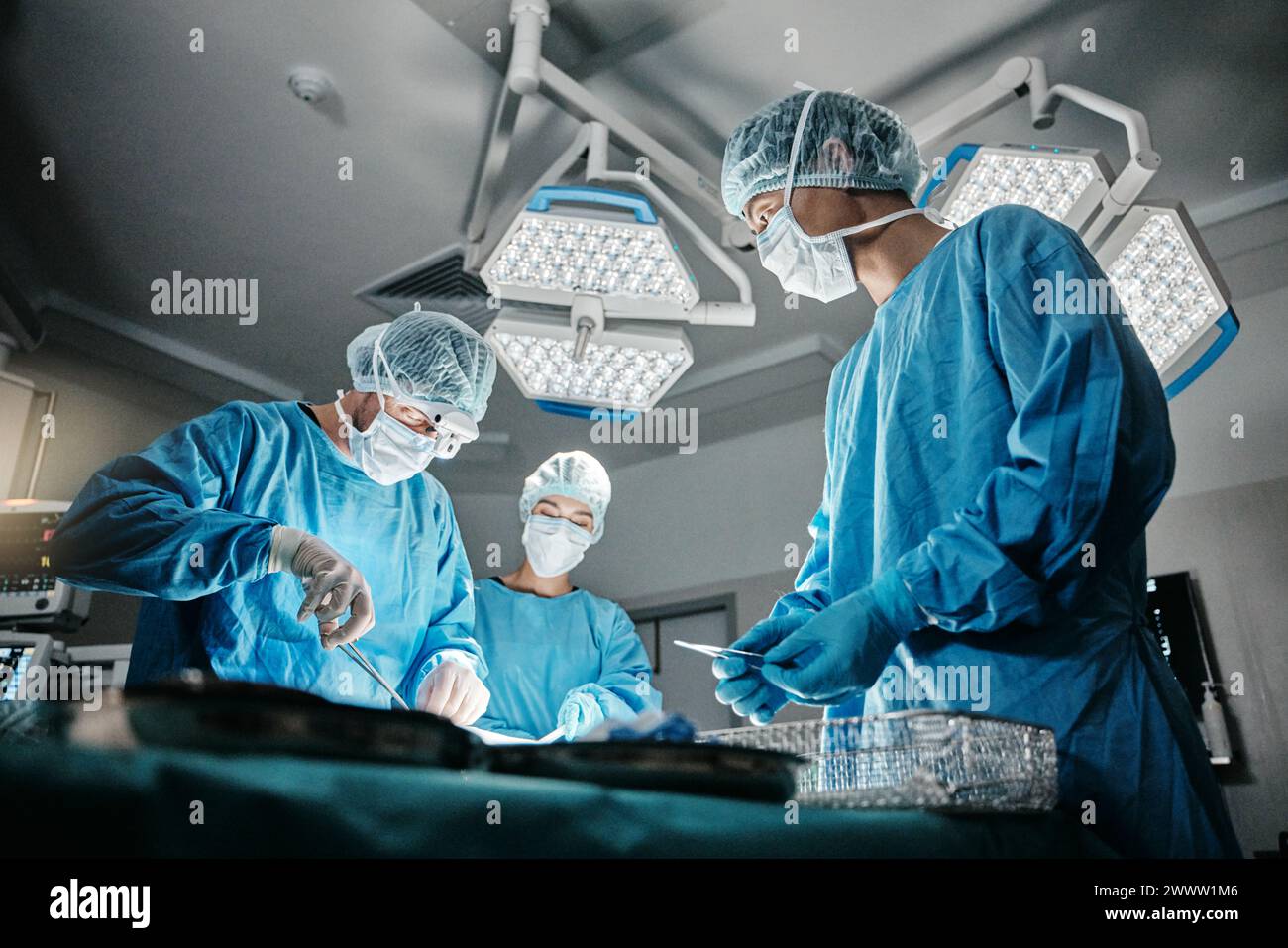 Surgeon group, procedure and operating room at hospital in scrubs, ppe ...