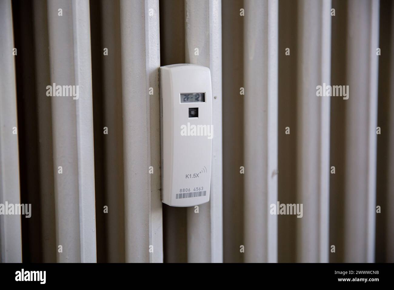Close up of a wireless heat meter on old white radiator. Heating of houses in the cold season Stock Photo