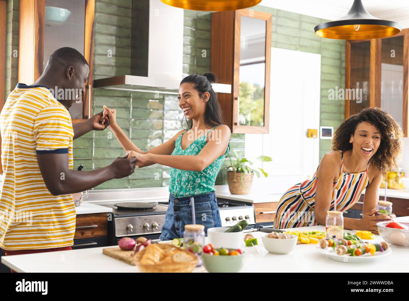 A group of friends is enjoying time together in a bright kitchen Stock ...