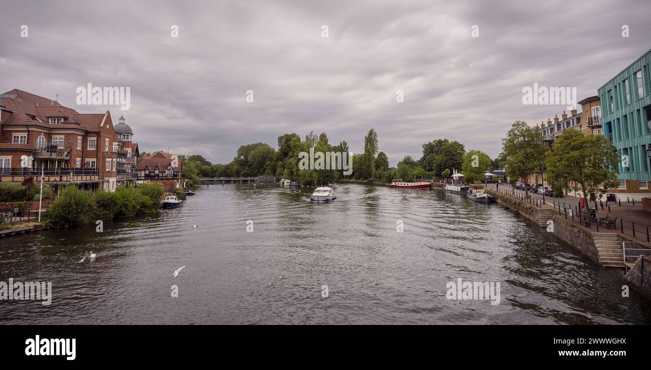 Panorama of the River Thames and Romney Island in Windsor England with buildings on the banks, boats in the water and a bird flying in the foreground Stock Photo