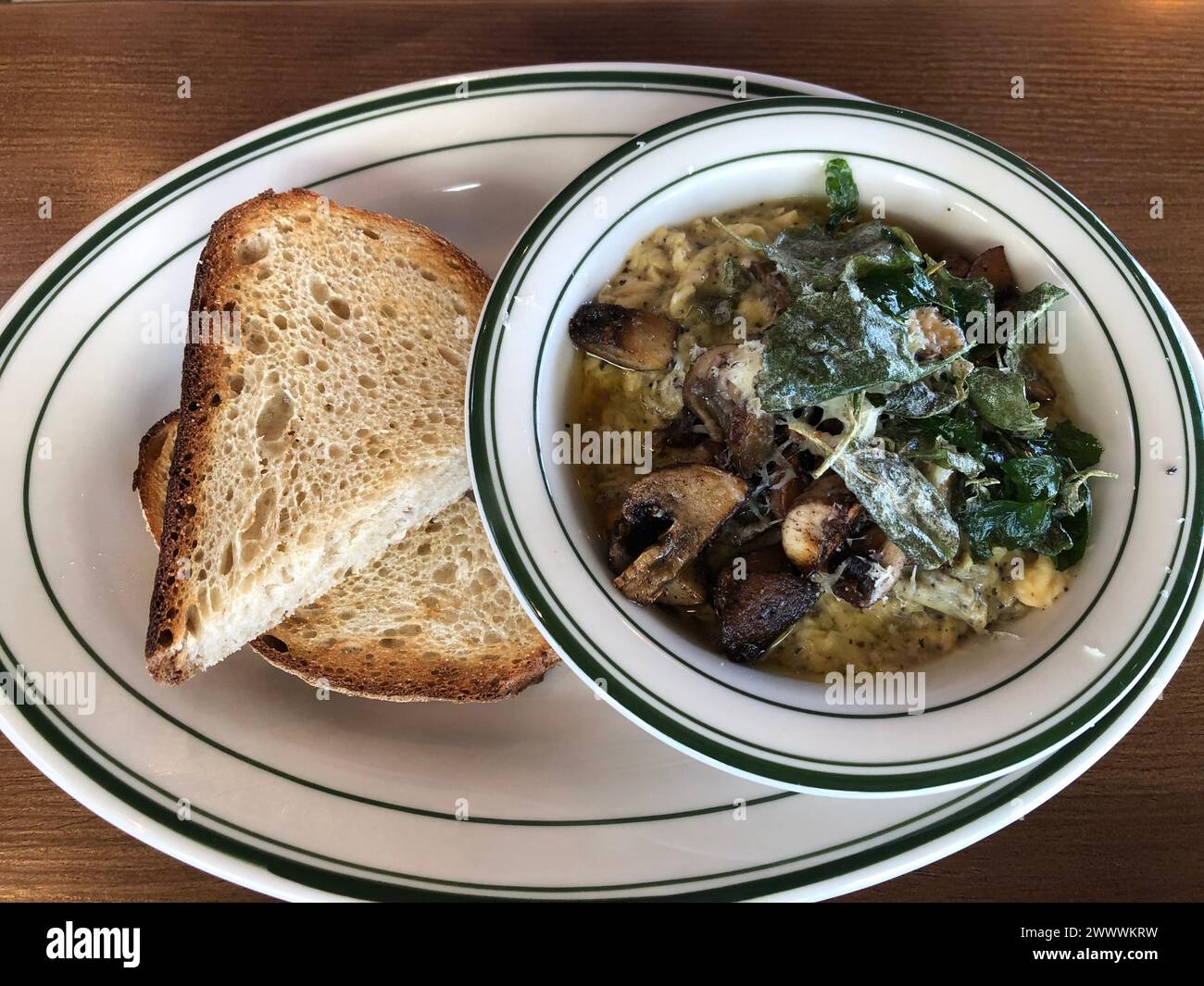 Bowl filled with soup and bread on a table Stock Photo