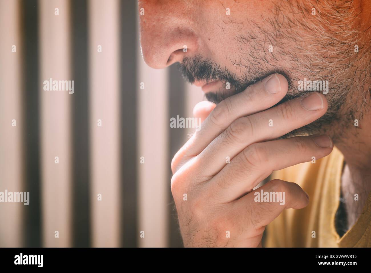 Mid adult man stroking chin and thinking, selective focus Stock Photo