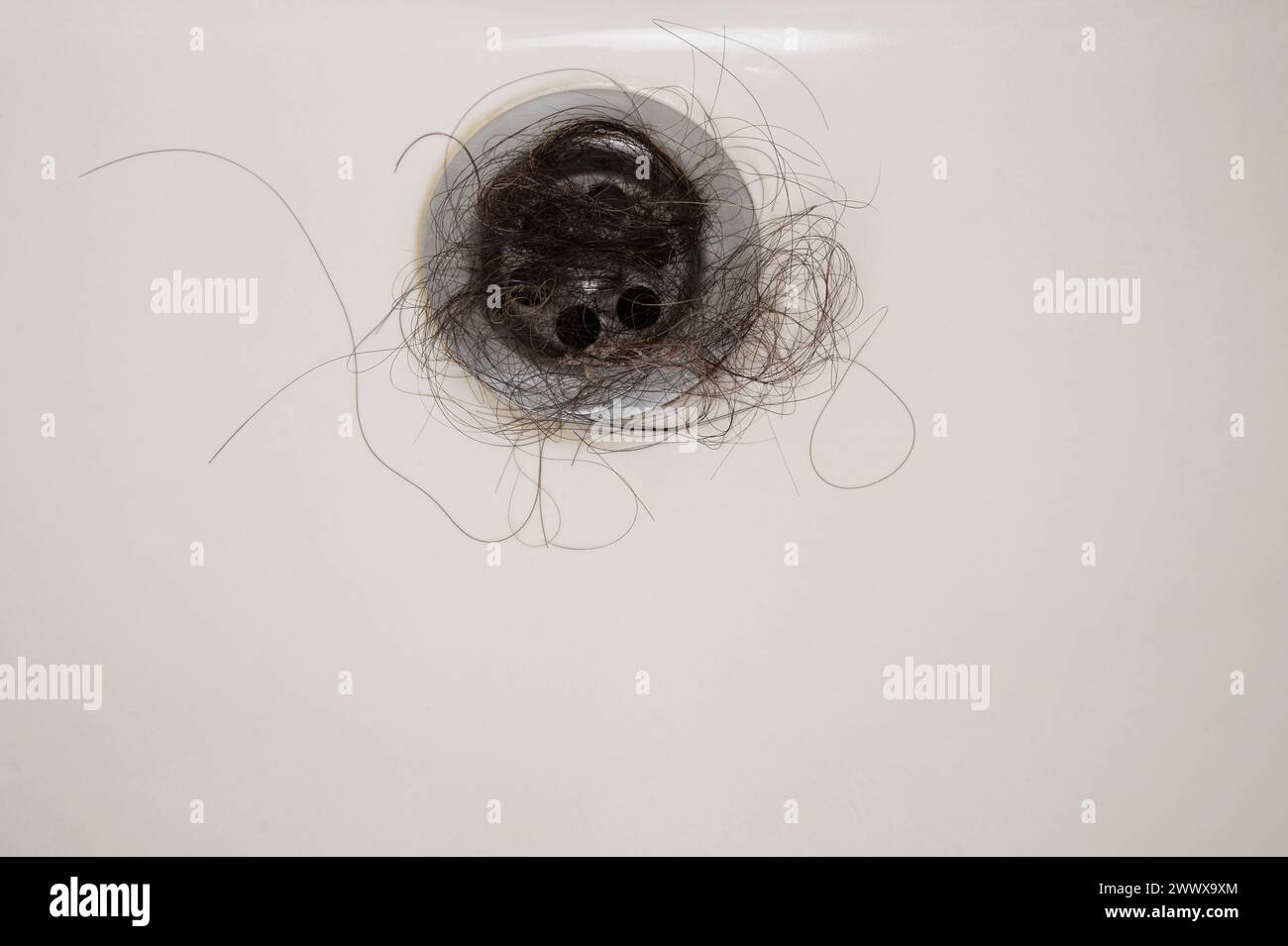 Stuck bathroom sink with dark hair clog close up view Stock Photo - Alamy
