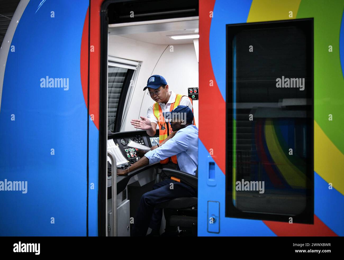(240326) -- LAGOS, March 26, 2024 (Xinhua) -- Chinese driver Wang Aofei (rear) guides trainee driver Awhangansi at the cab on a train of the Lagos Rail Mass Transit (LRMT) Blue Line in Lagos, Nigeria, March 3, 2024. Undertaken by China Civil Engineering Construction Corporation (CCECC) in July 2010 and completed in Dec. 2022, the first phase of the Lagos Rail Mass Transit (LRMT) Blue Line corridor spans 13 km and covers five stations. It began commercial operation in Sept. of 2023. As a symbolic project of the Belt and Road Initiative, the Blue Line project is the first electrified railroad an Stock Photo