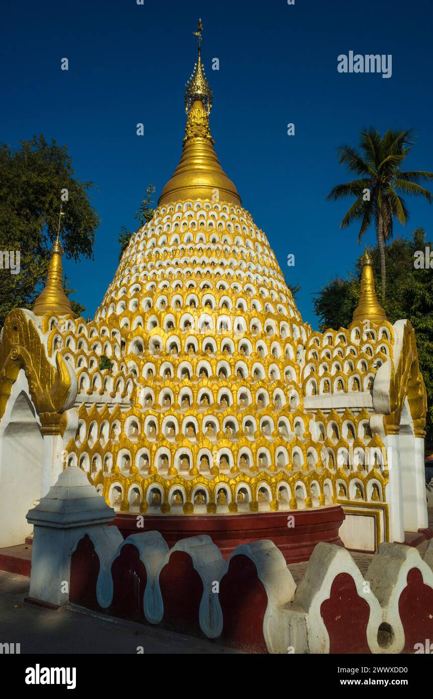 Buddhist pagoda decorated with thousand small Buddha sculptures meditating in caves. Amarapura, Mandalay, Myanmar Stock Photo