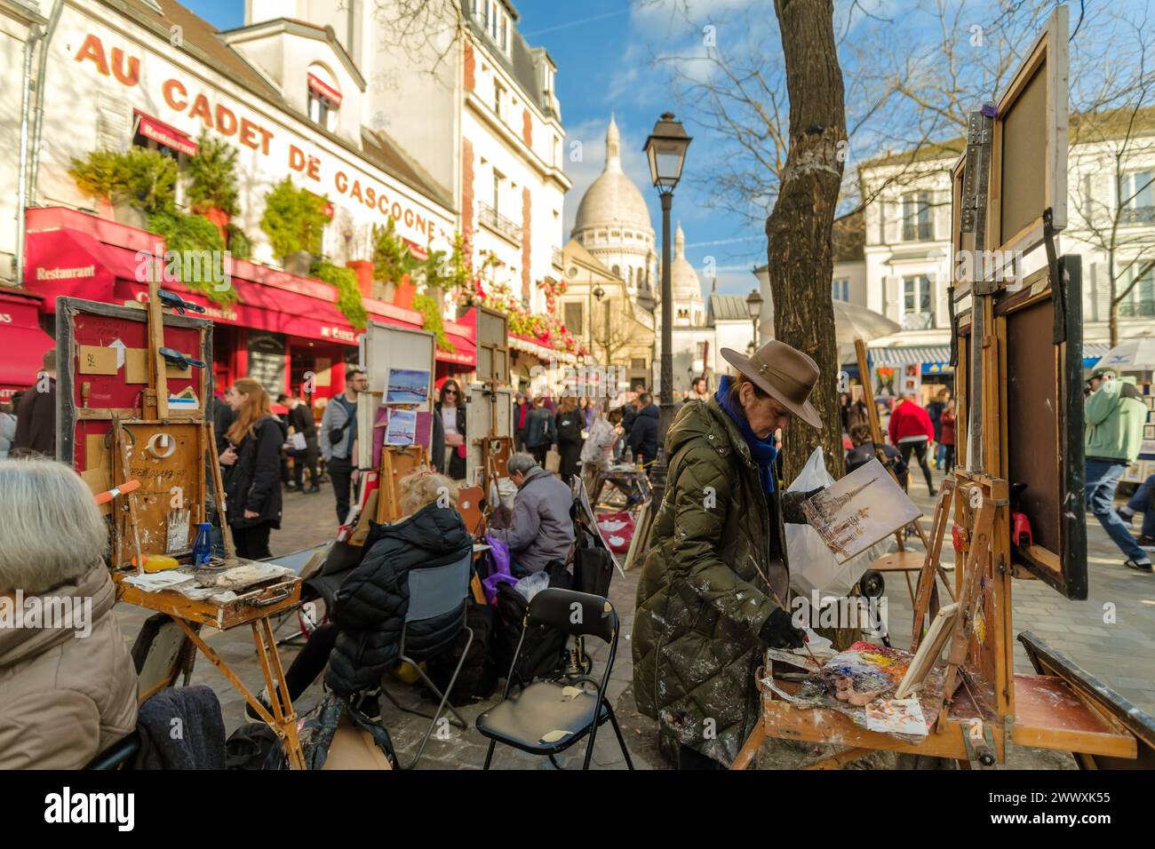 Paris, France - February 17, 2024 : Panoramic view of the busy and picturesque Montmartre square, famous for artists and restaurants in Paris France Stock Photo