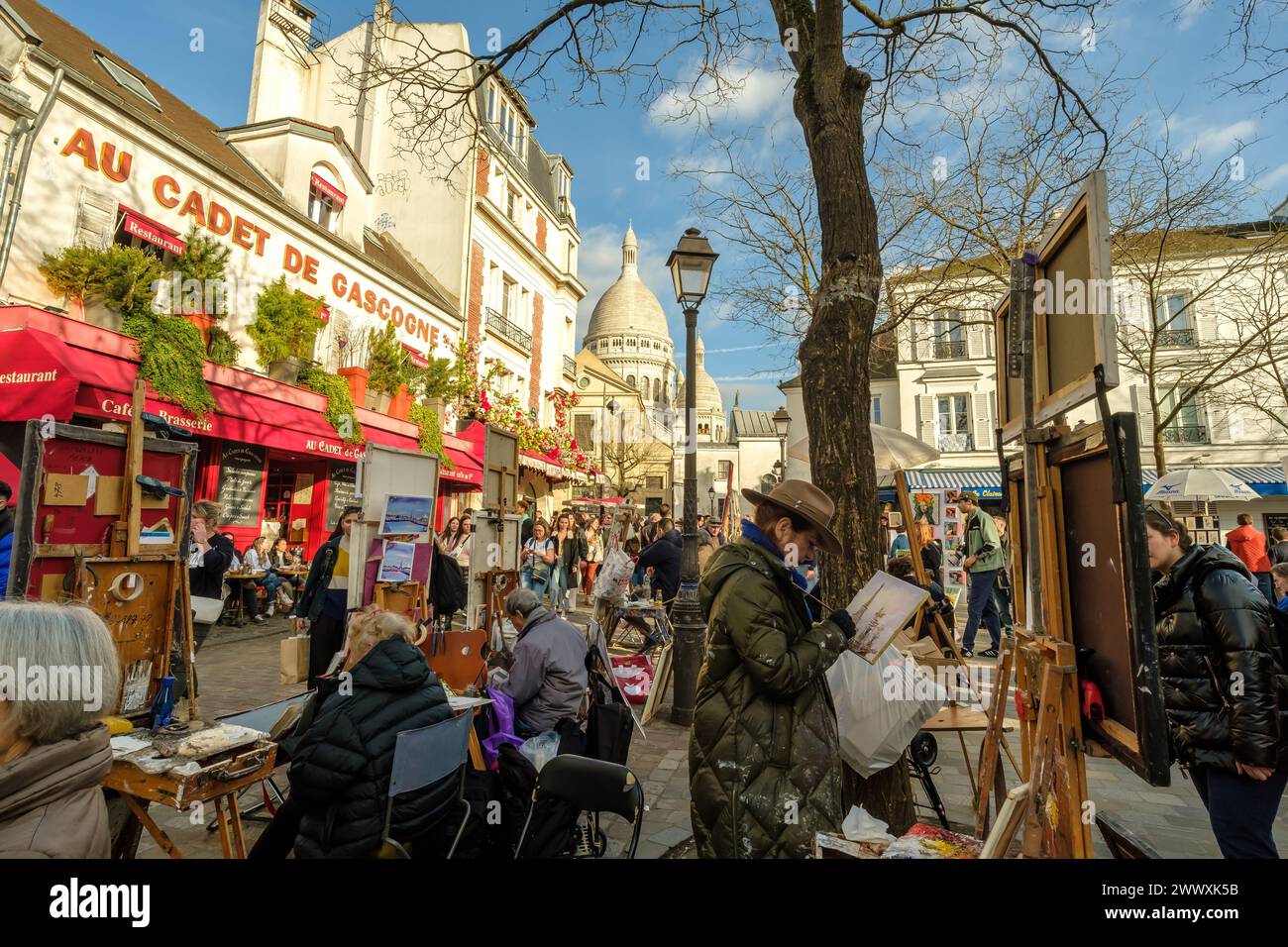 Paris, France - February 17, 2024 : Panoramic view of the busy and picturesque Montmartre square, famous for artists and restaurants in Paris France Stock Photo