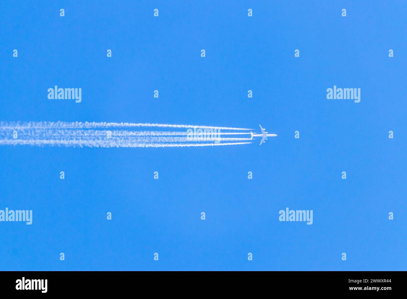 Aircraft with vapour trail (contrail) Stock Photo