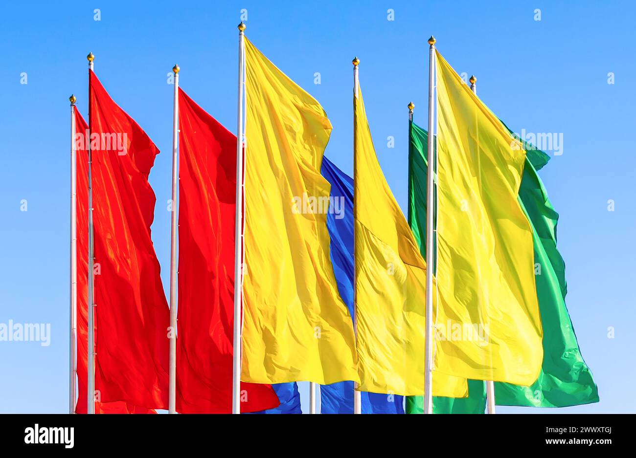 Colorful flags fluttering against a blue sky background Stock Photo - Alamy