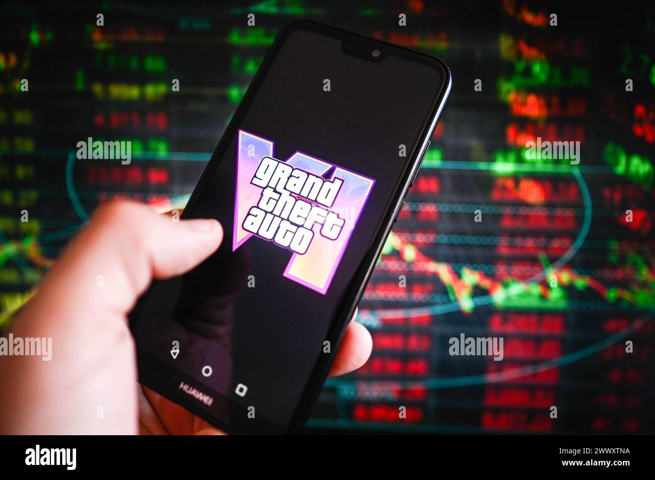In this photo illustration, a Grand Theft Auto VI logo is displayed on a smartphone with stock market percentages in the background. Stock Photo