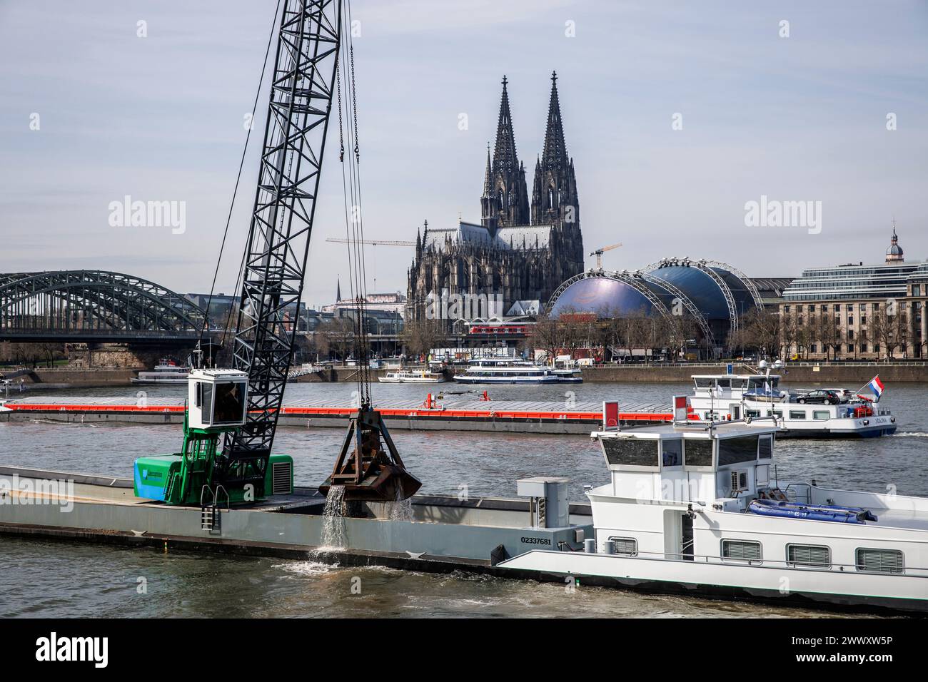 excavator on a ship deepens the riverbed of the river Rhine, the cathedral, Cologne, Germany. Bagger auf einem Schiff vertieft die Fahrrinne des Rhein Stock Photo