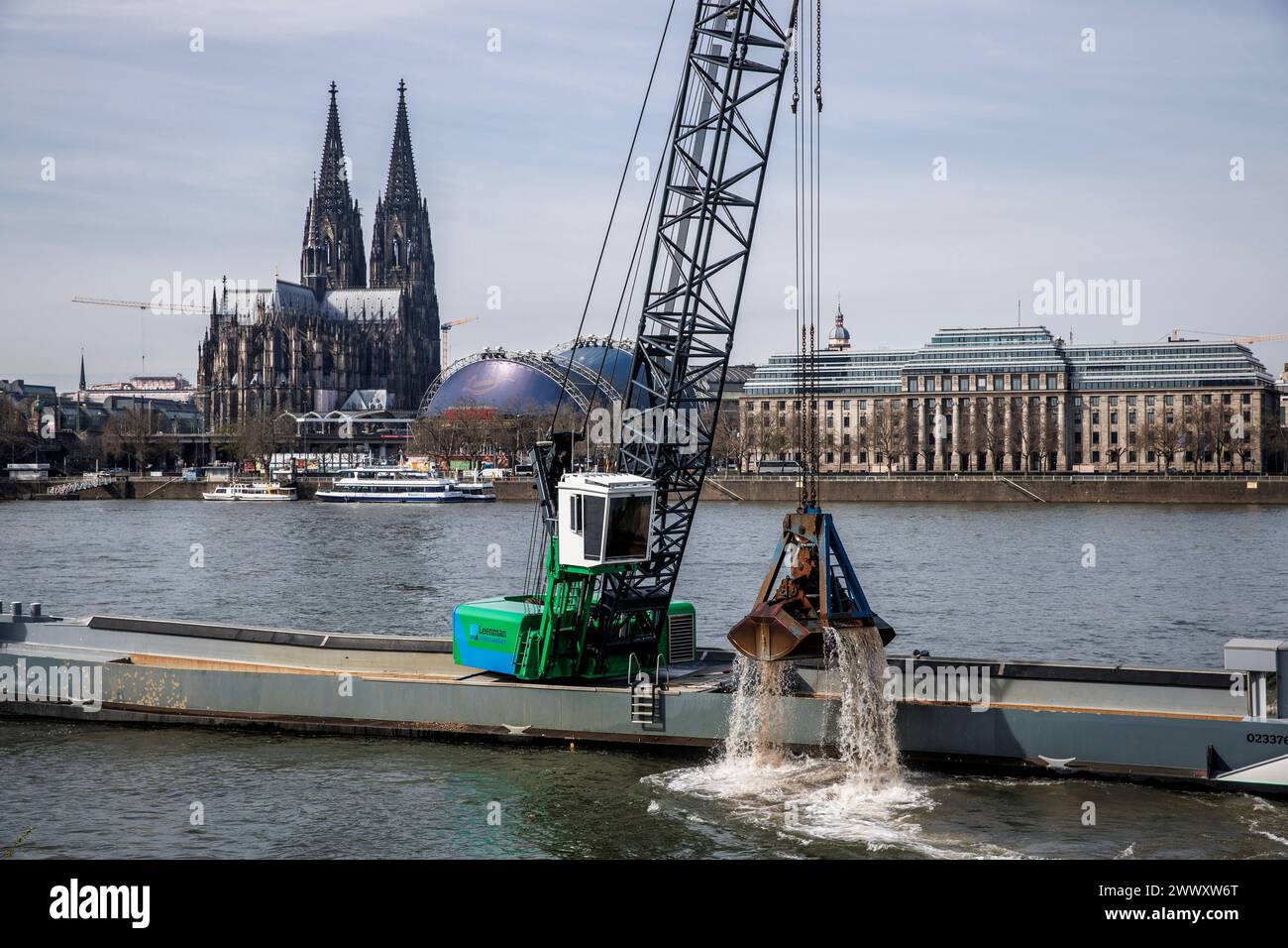 excavator on a ship deepens the riverbed of the river Rhine, the cathedral, Cologne, Germany. Bagger auf einem Schiff vertieft die Fahrrinne des Rhein Stock Photo