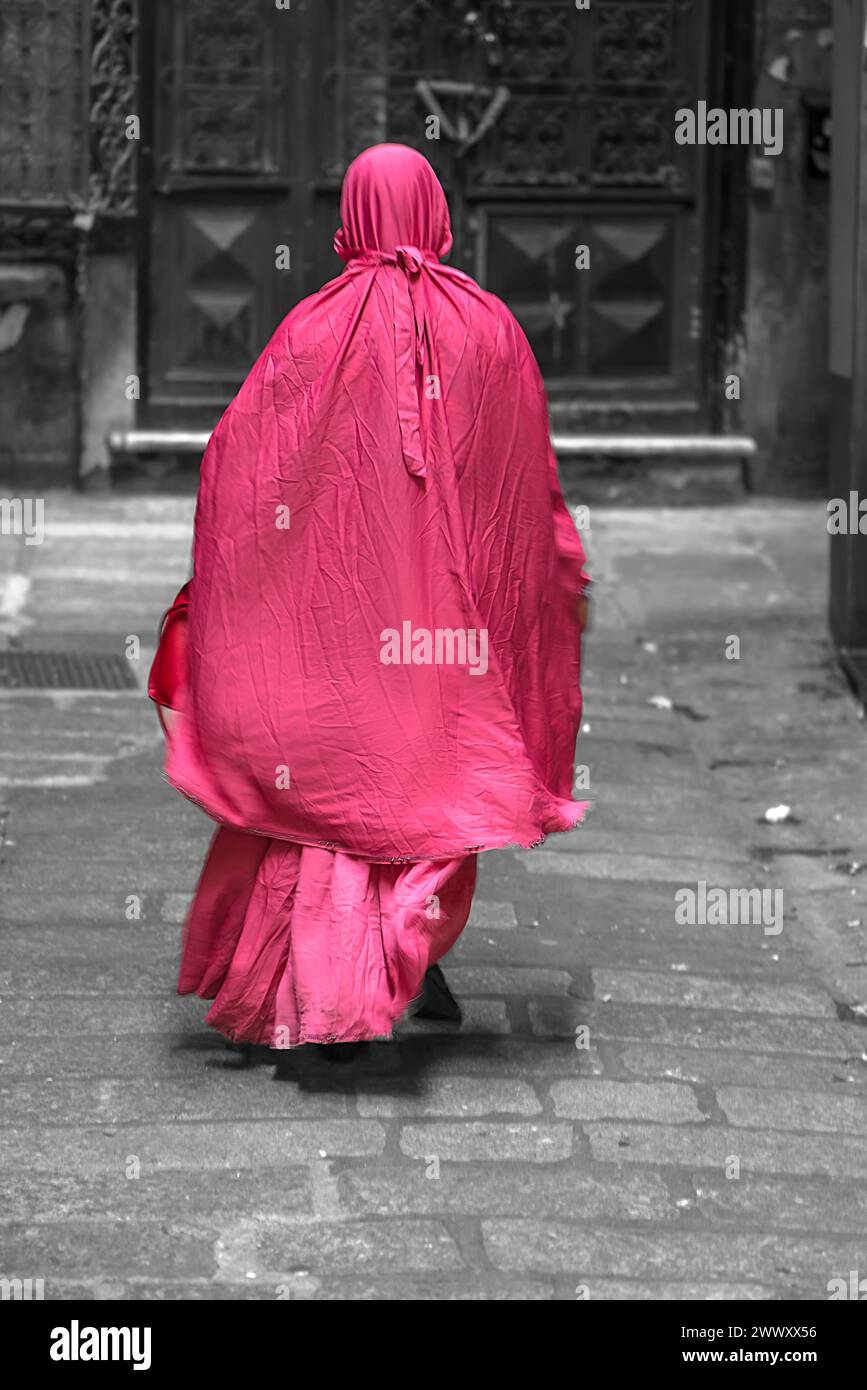 Woman with red robe in the streets of the historic centre, Genoa, Italy Stock Photo