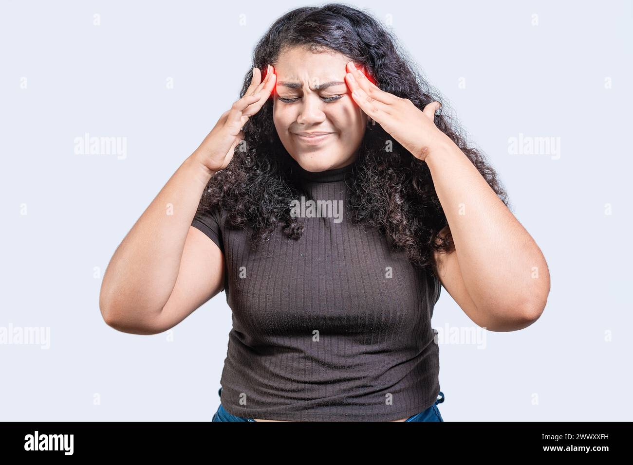 Young woman with headache isolated. Girl suffering from migraine holding head. Headache concept Stock Photo