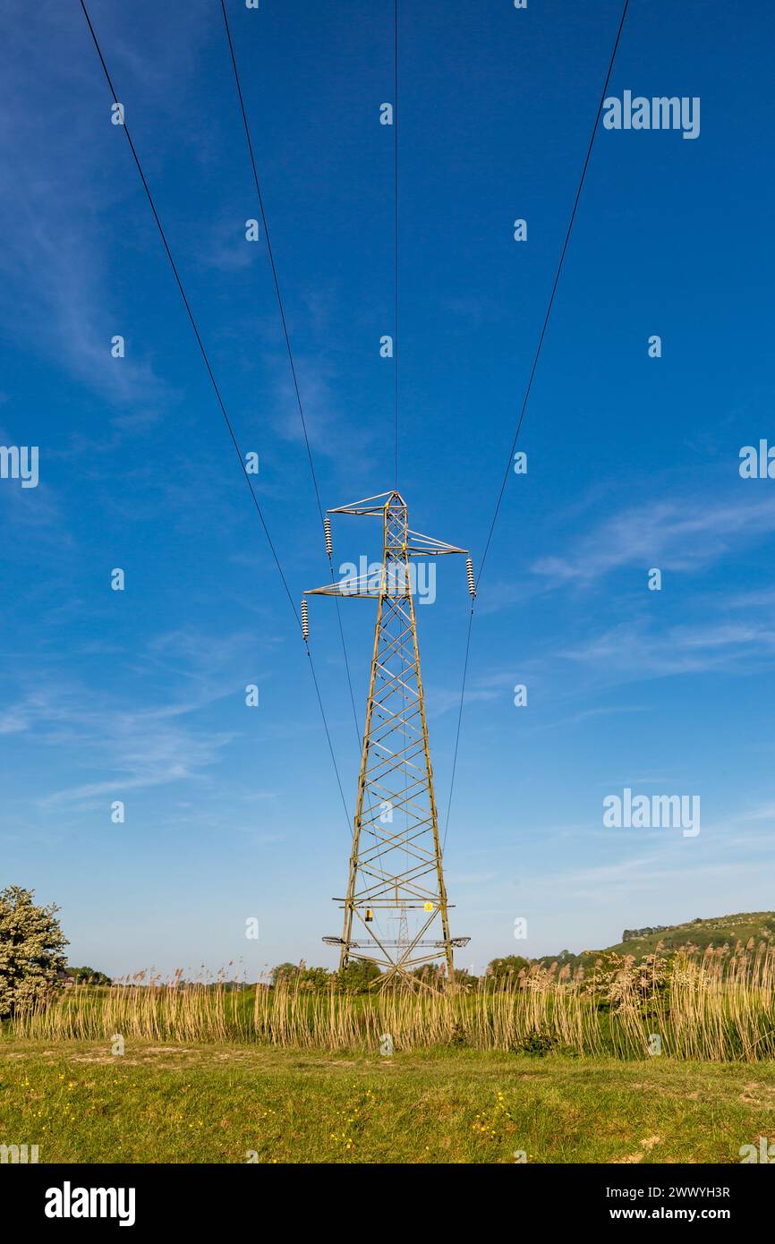 An electricity pylon in the Sussex countryside, with a blue sky ...