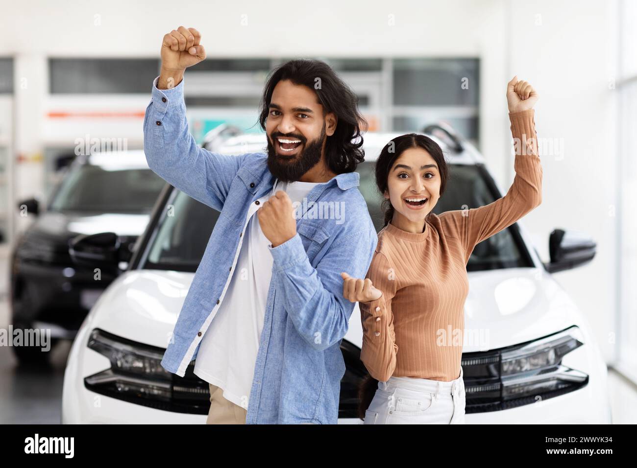 Excited hindu couple celebrating a new car purchase Stock Photo