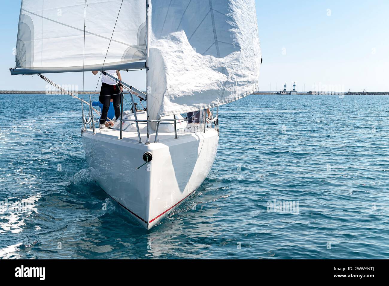 Sleek yacht with crew embarks on a regatta race, showcasing the thrill of sailing in the clear mediterranean sea Stock Photo