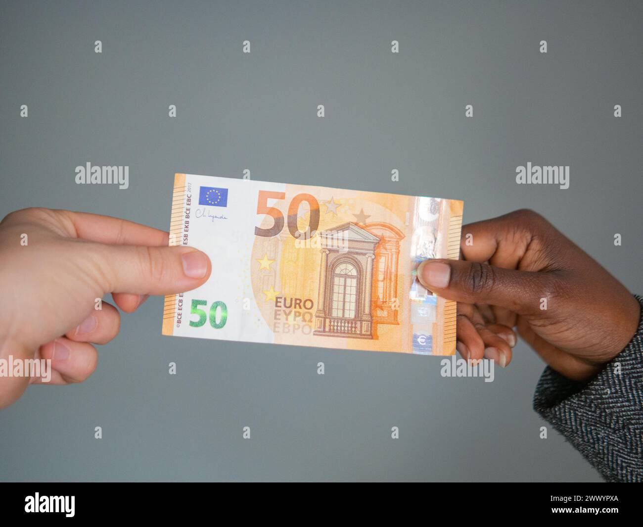 Two hands holding a fifty euro note Stock Photo