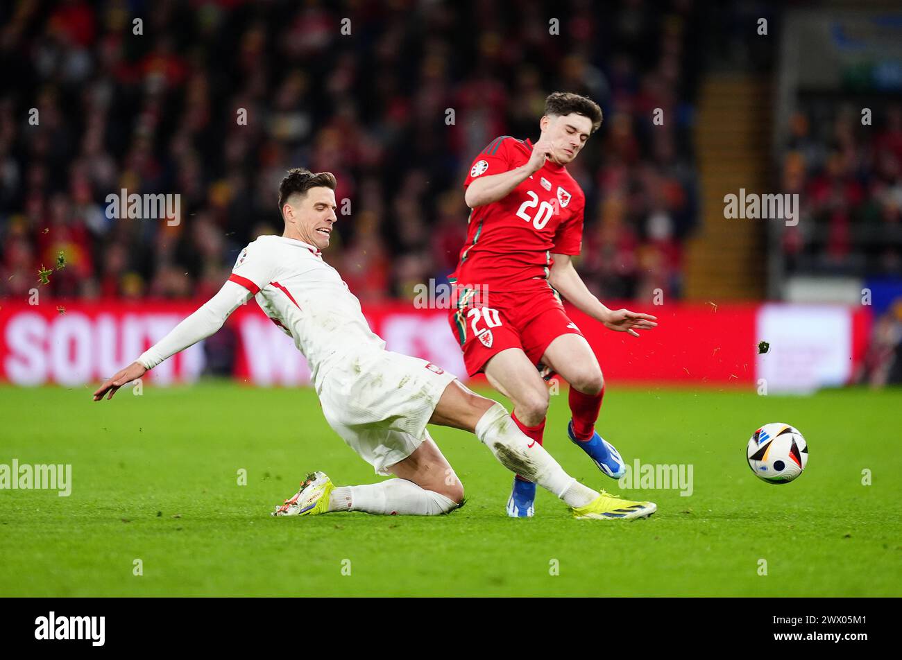 Wales' Daniel James and Poland's Jan Bednarek (left) battle for the ball during the UEFA Euro 2024 Qualifying play-off final at the Cardiff City Stadium, Wales. Picture date: Tuesday March 26, 2024. Stock Photo