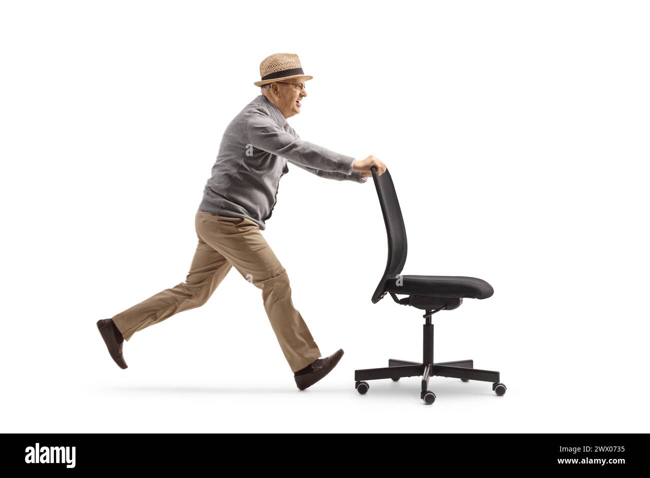 Elderly man running and pushing an office chair isolated on white ...