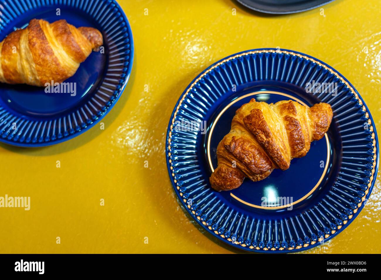 croissant colorful blue yellow flat lay in a bakery on a plate . Stock Photo