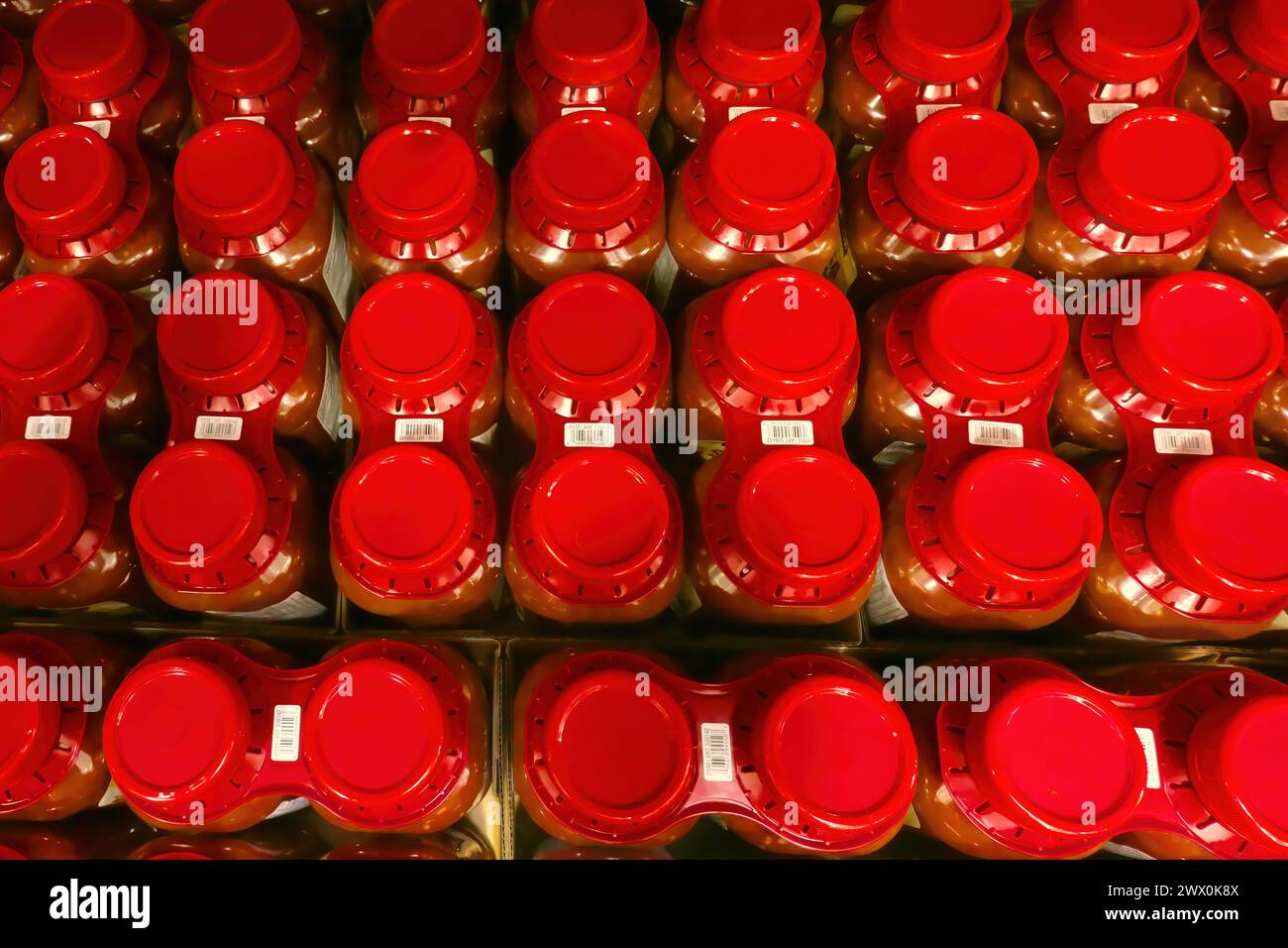 Looking down on red lids of plastic jars of Salsa on a store shelf. Stock Photo