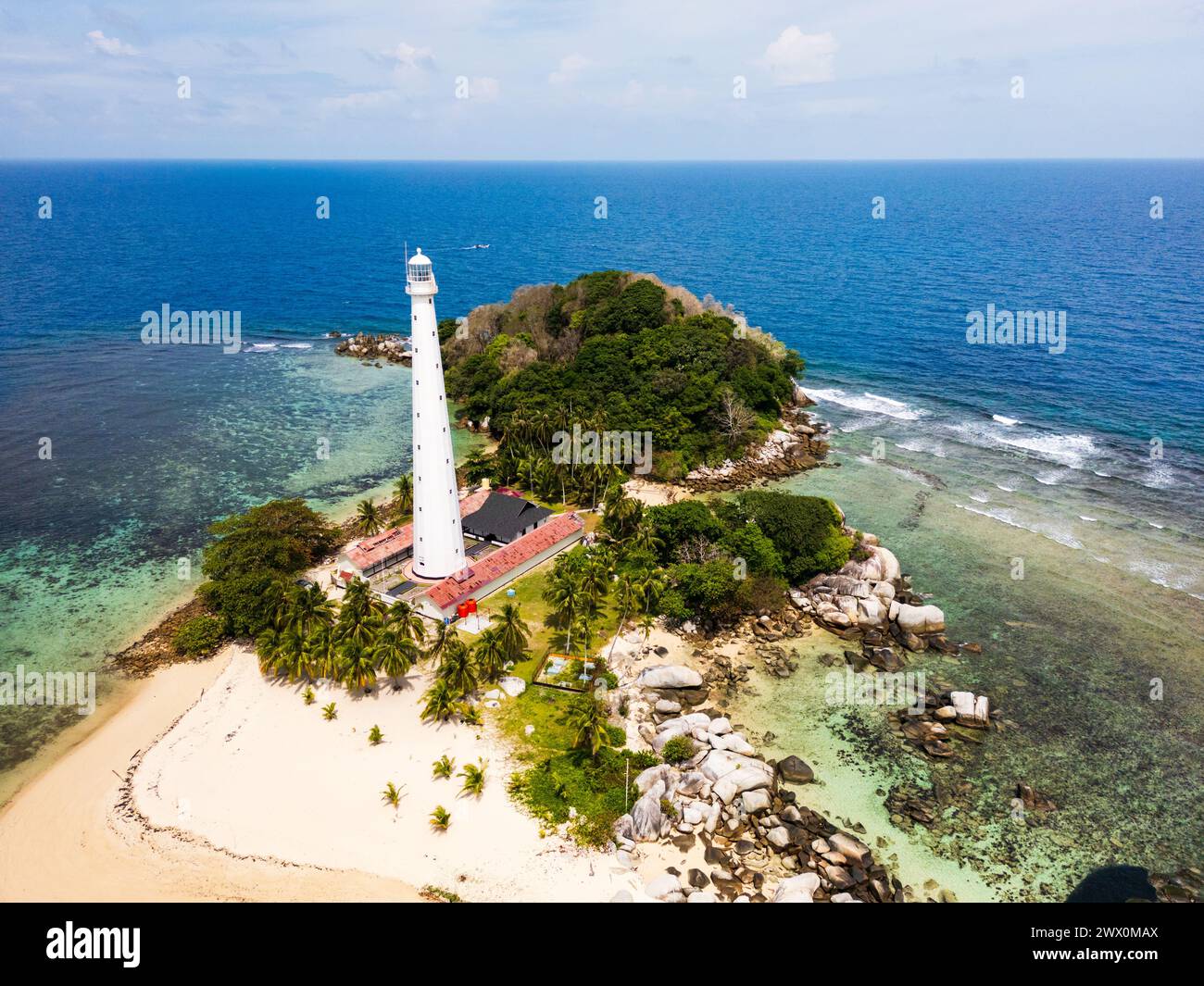 Belitung beach and islands drone view with Lengkuas Island lighthouse. Beautiful aerial view of islands, boat, sea and rocks in Belitung, Indonesia  Stock Photo