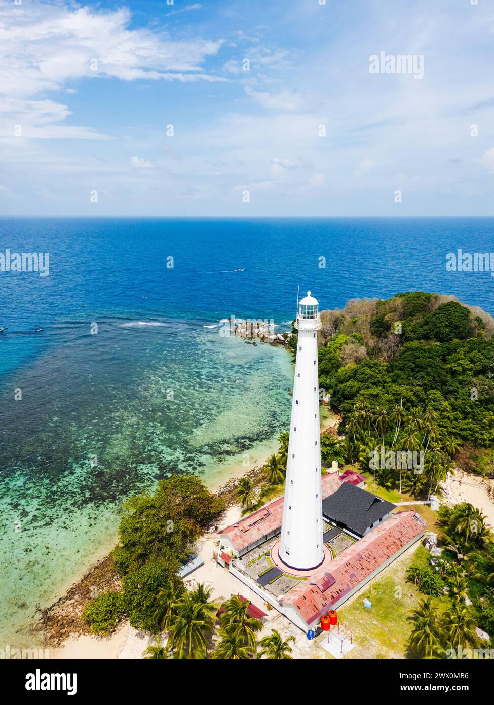 Belitung beach and islands drone view with Lengkuas Island lighthouse. Beautiful aerial view of islands, boat, sea and rocks in Belitung, Indonesia  Stock Photo