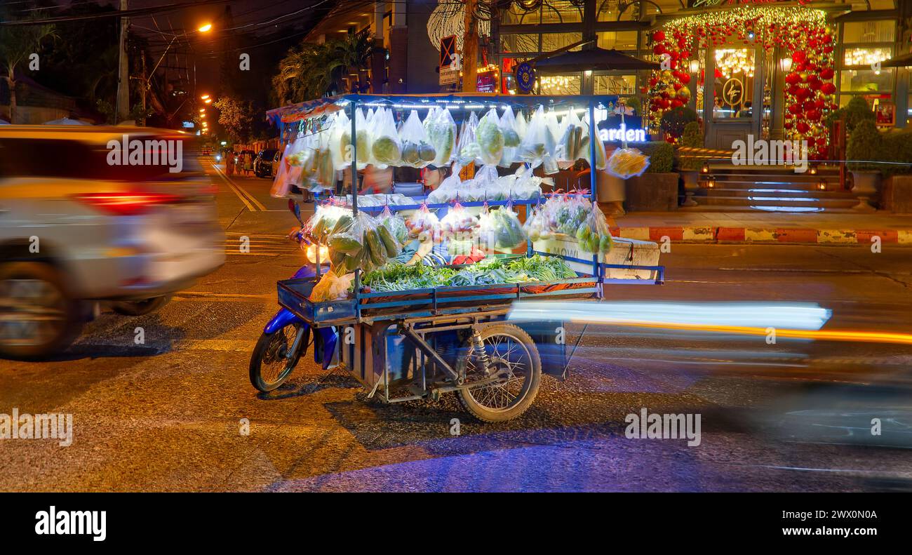 Motorcycle merchants on city streets at night with blur and long exposure lights in Pattaya, Thailand Stock Photo