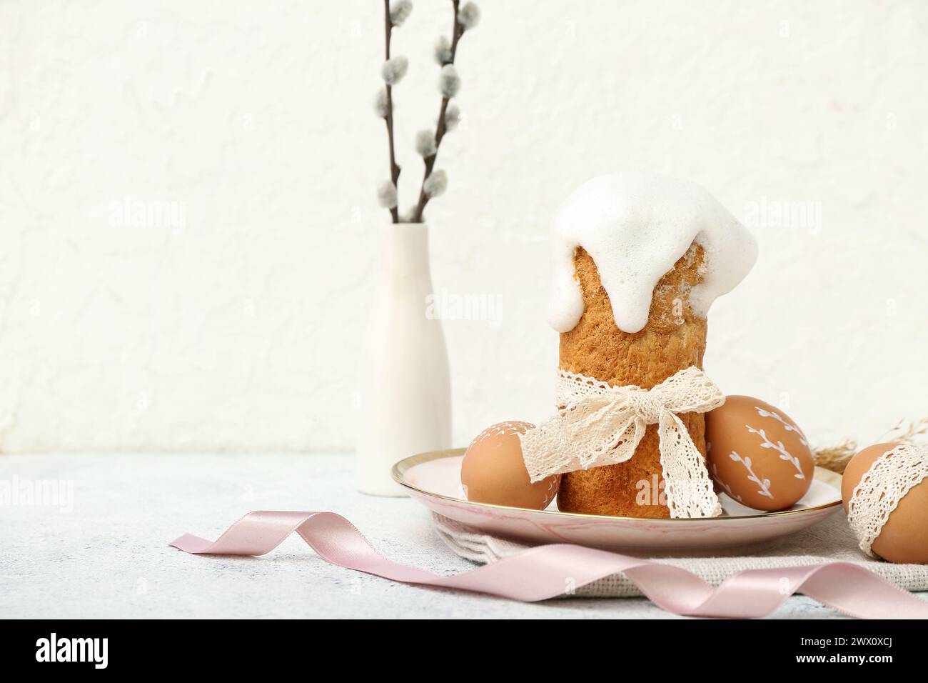Plate with Easter cake, eggs and willow branches on white background Stock Photo