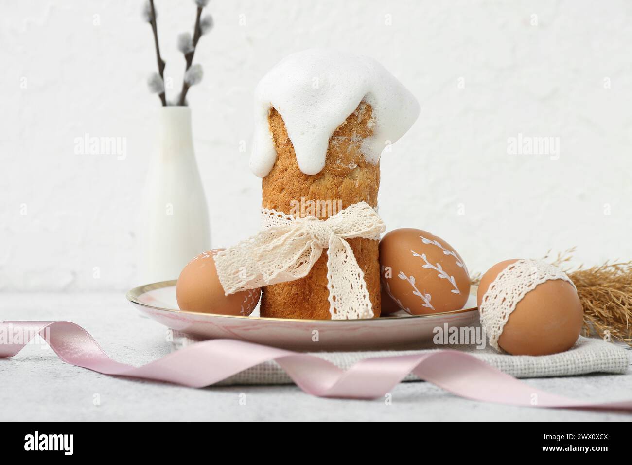 Plate with Easter cake, eggs and willow branches on white background Stock Photo