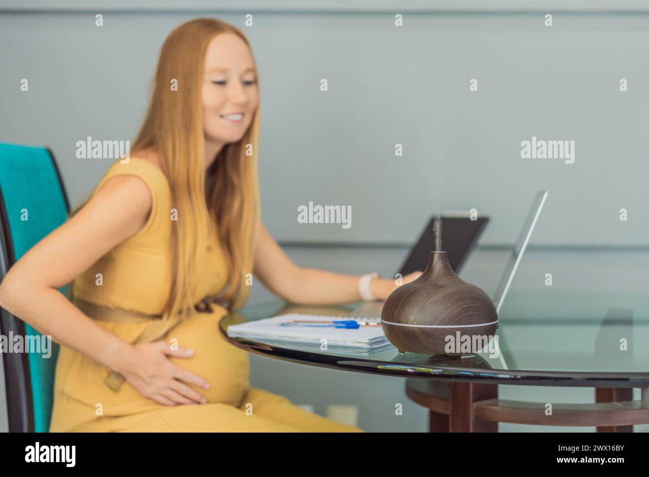 Expectant woman enhances work environment, using an aroma diffuser for