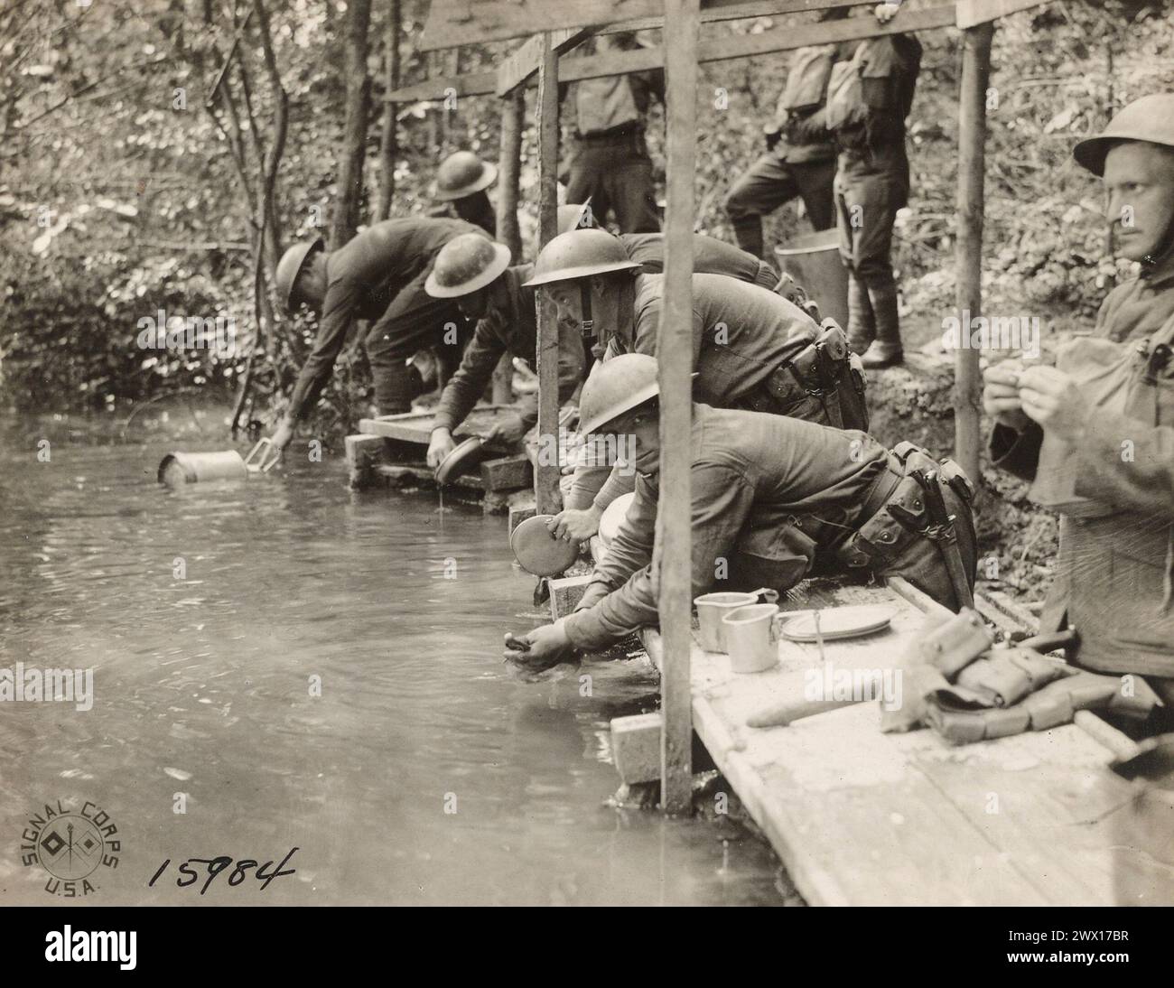 Soldiers of Company E, 125th Infantry, 32nd Division, washing mess kits in a stream near the front; Michelbach, Alsace, Germany ca. 1918 Stock Photo