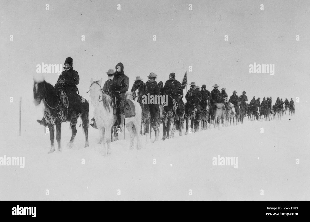 Return of Casey's scouts from the fight at Wounded Knee, 1890--91.' Soldiers on horseback plod through the snow ca. 1890-1891 Stock Photo