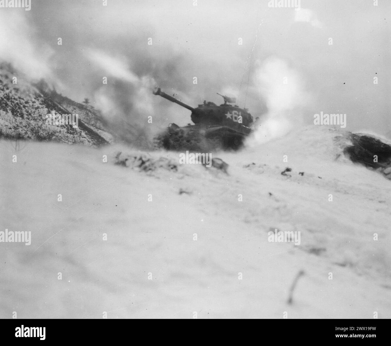 Near Song Sil-li, Korea, a tank of 6th Tank Battalion, fires on enemy positions in support of the 19th Regimental Combat Team ca. January 1952 Stock Photo