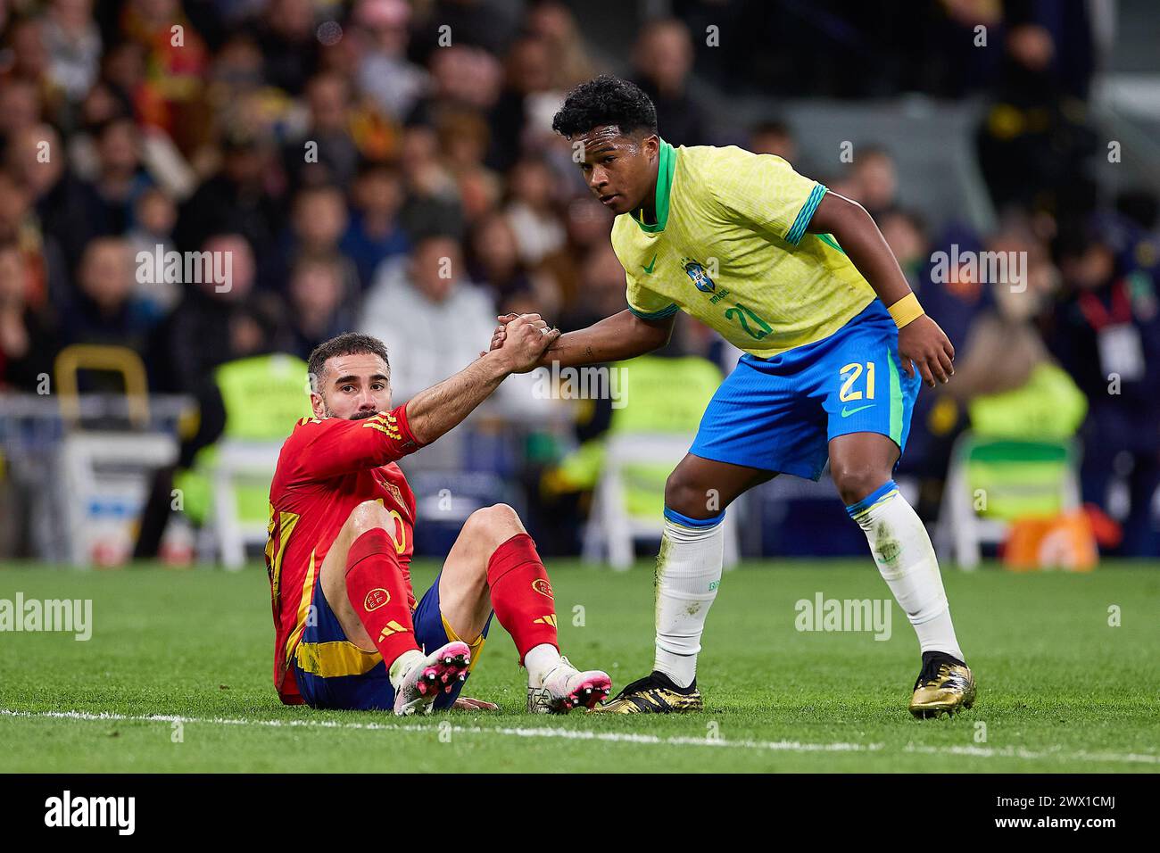 Madrid, Spain. 26th Mar, 2024. Endrick Felipe Moreira de Sousa, known as Endrick (R) of Brazil helps Daniel Carvajal (L) of Spain to stand up during the international friendly match between Spain and Brazil at Santiago Bernabeu Stadium. Final score: Spain 3:3 Brazil (Photo by Federico Titone/SOPA Images/Sipa USA) Credit: Sipa USA/Alamy Live News Stock Photo