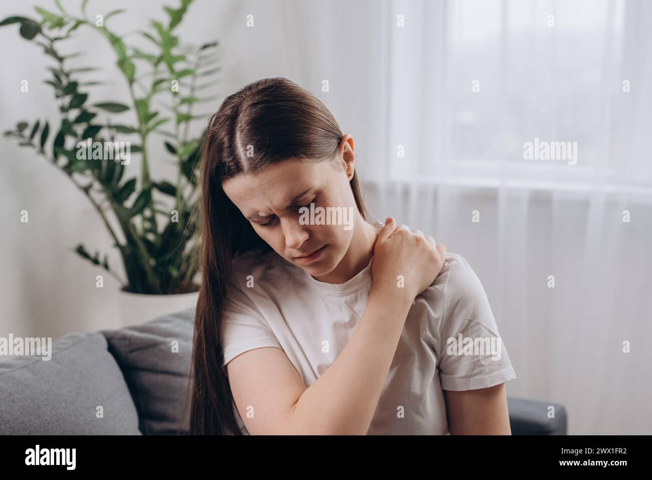 Ill tired young caucasian woman massaging rubbing stiff sore neck