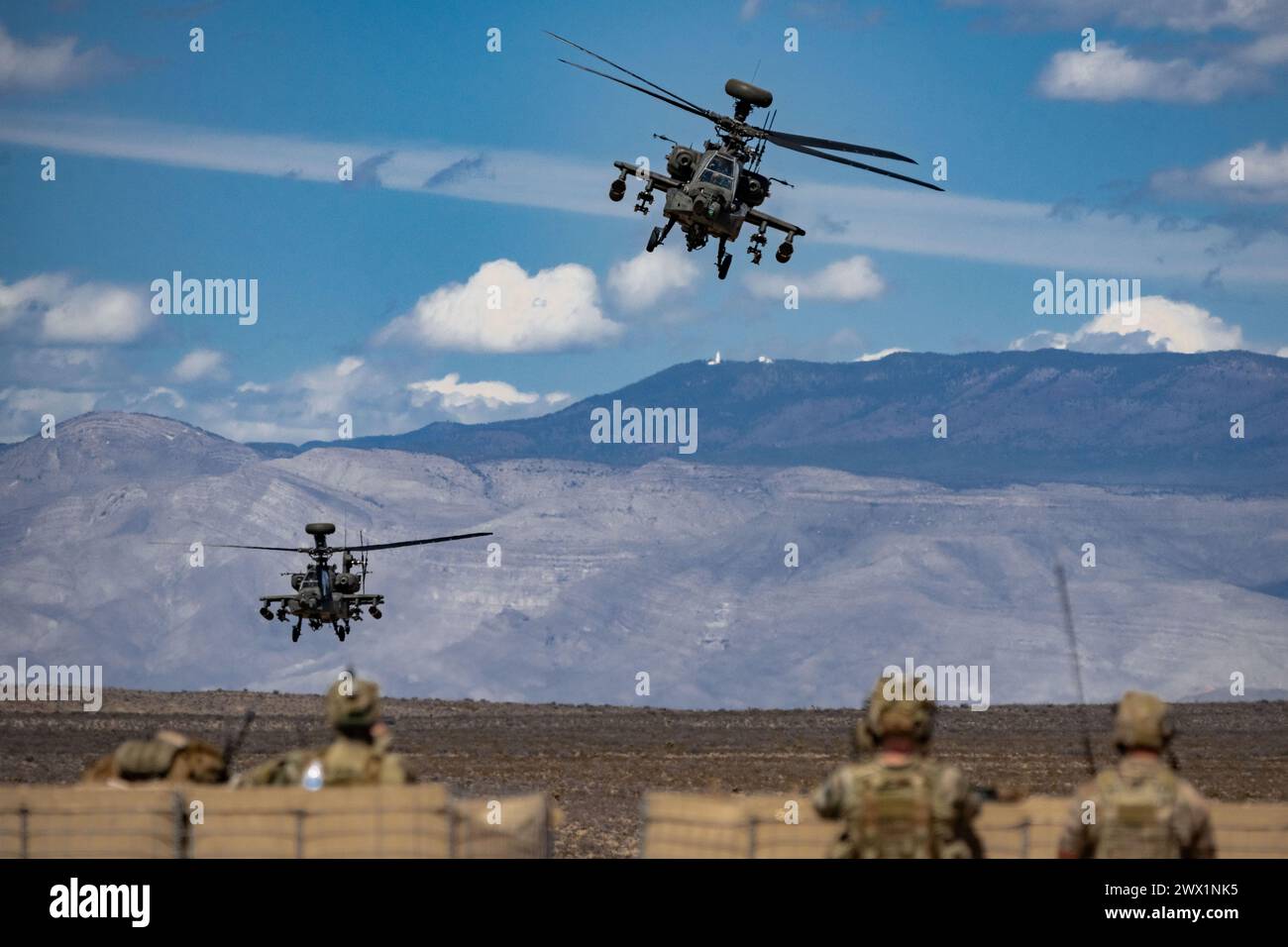 AH-64 Apaches from the 3rd Squadron, 6th Cavalry, 1st Armored Division Combat Aviation Brigade, maneuver over a ridge during Operation Sandlot Stock Photo