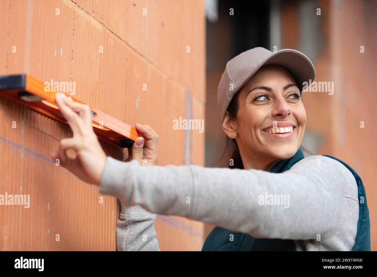 female builder keeps the building level in front of her Stock Photo