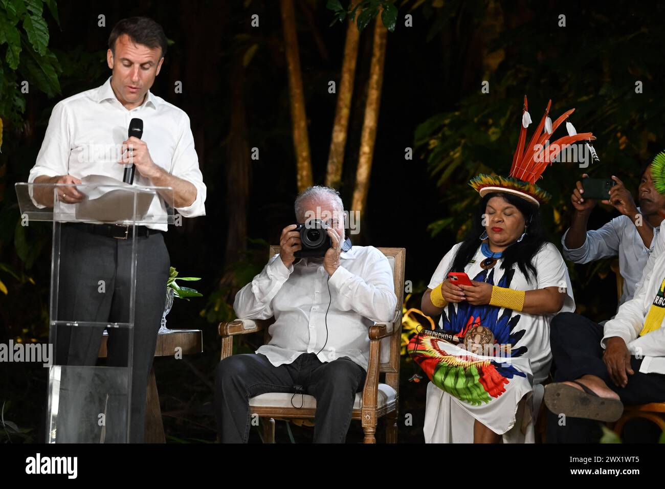 French President Emmanuel Macron speaks as Brazilian President Luiz Inacio Lula Da Silva takes pictures next to the Minister of Indigenous Peoples and longtime activist Sonia Guajajara during a meeting at Combu Island, in front of Belem, state of Para, Brazil, on March 26, 2024. French and Brazilian presidents Emmanuel Macron and Luiz Inacio Lula da Silva launched a program Tuesday aimed at raising up to one billion euros in green investments in the Brazilian and Guyanese Amazon, the French presidency announced. Photo by Jacques Witt/Pool/ABACAPRESS.COM Stock Photo