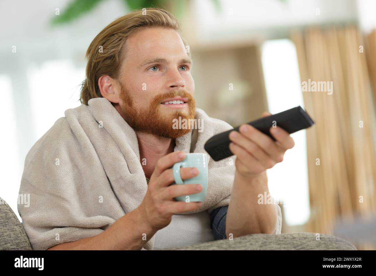 portrait of cheerful man changing channels Stock Photo