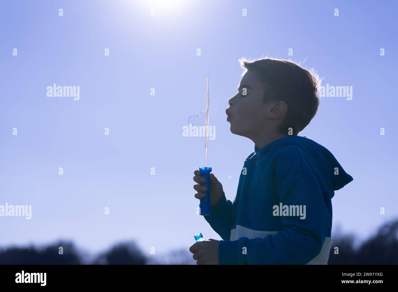 Child playing blowing soap bubbles in nature Stock Photo - Alamy