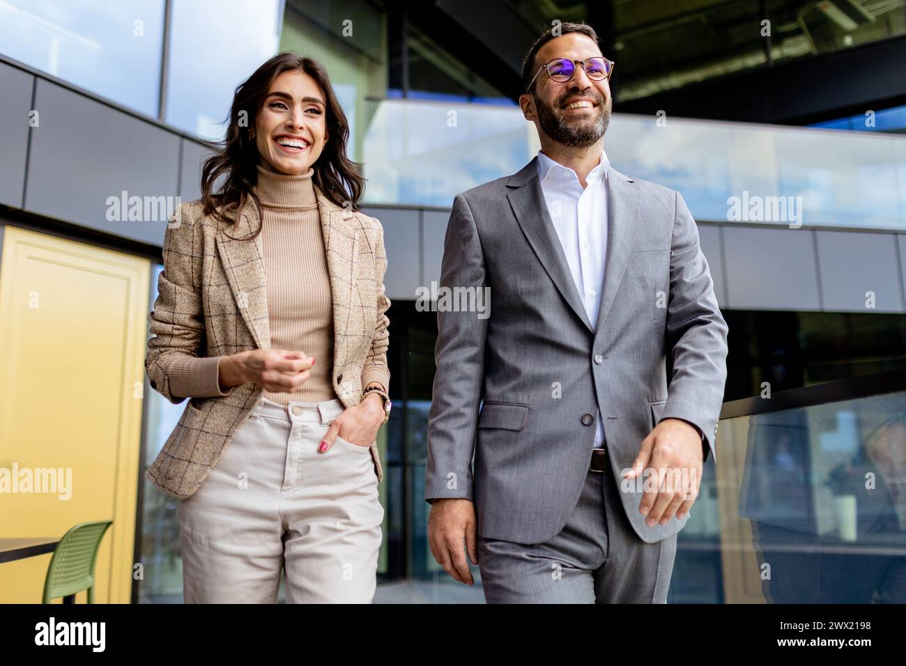 Two professionals exude confidence and happiness as they walk out of a ...