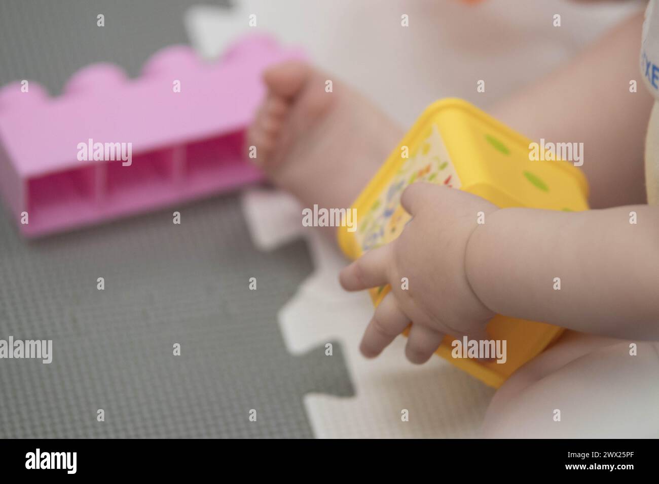 Child playfully handles blocks and other toys at childcare while