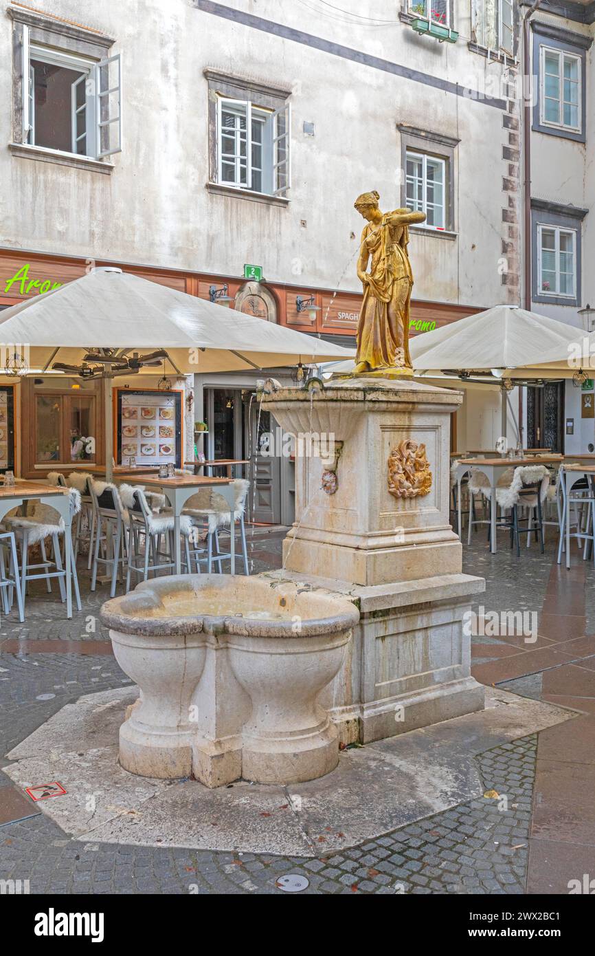 Ljubljana, Slovenia - November 4, 2019: Golden Water Fountain Landmark at Ribji Square in Capital City Rainy Fall Day. Stock Photo