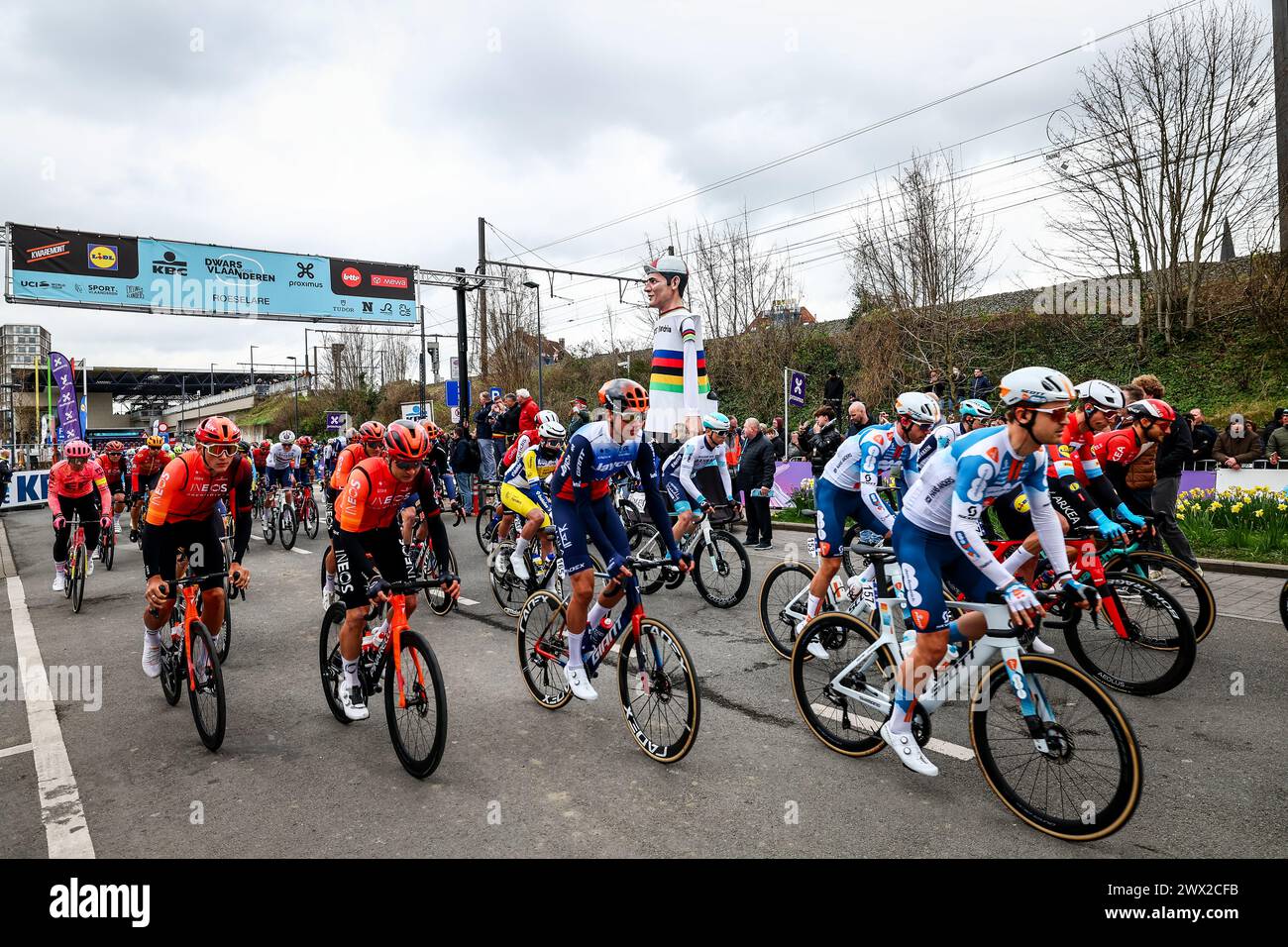 Roeselare, Belgium. 27th Mar, 2024. The pack of riders pictured at the start of the men elite race of the 'Dwars Door Vlaanderen' cycling race, 188, 6 km from Roeselare to Waregem, Wednesday 27 March 2024. BELGA PHOTO DAVID PINTENS Credit: Belga News Agency/Alamy Live News Stock Photo