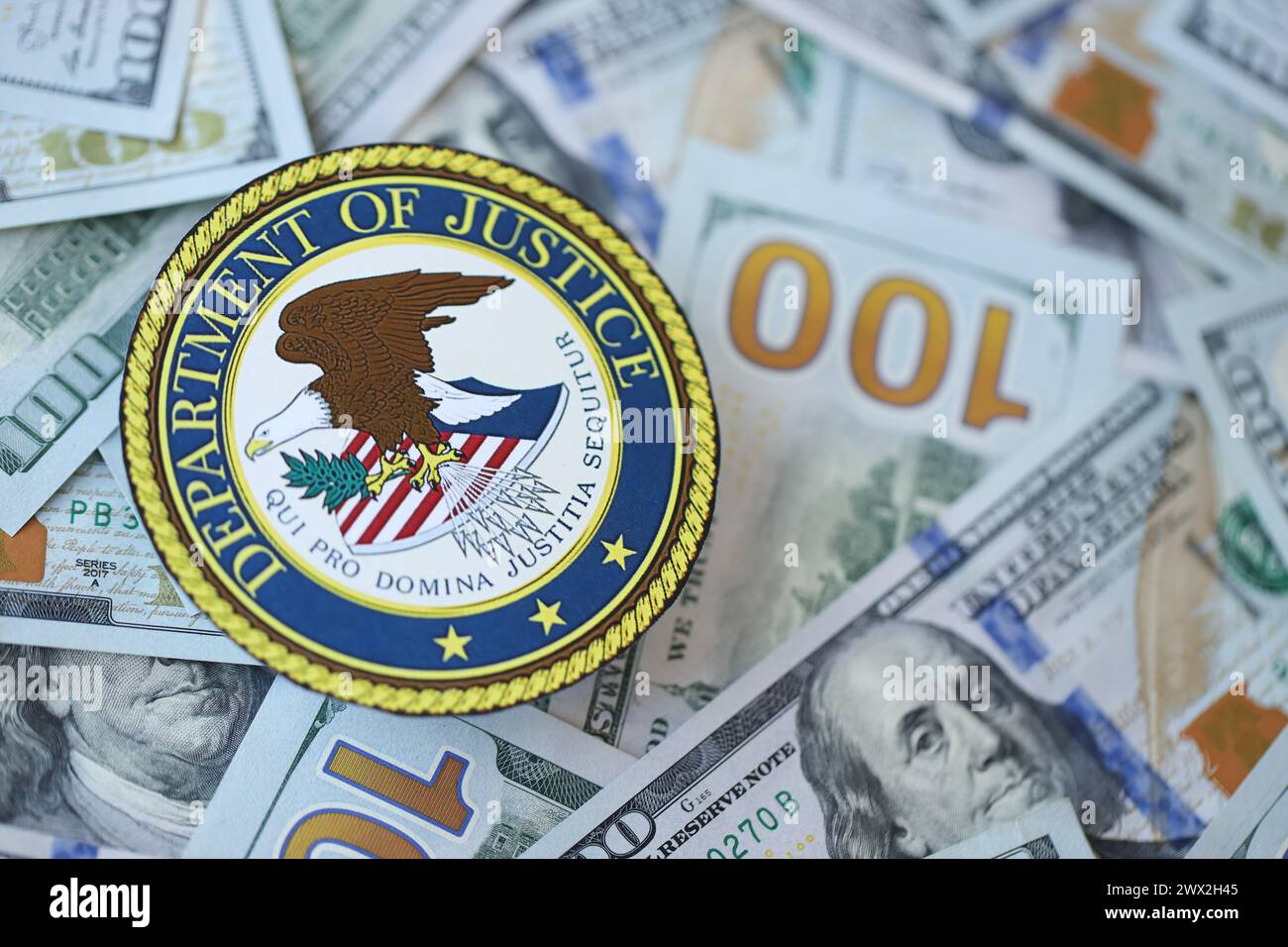 KYIV, UKRAINE - MARCH 9, 2024 US Department of Justice seal on many US hundred dollar bills close up Stock Photo