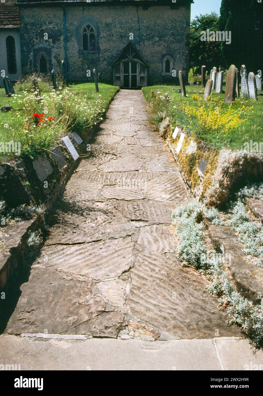 Clayton, St John the Baptist's church, West Sussex.  Looking south along path to church showing the ripple marks in the Horsham flagstones Stock Photo