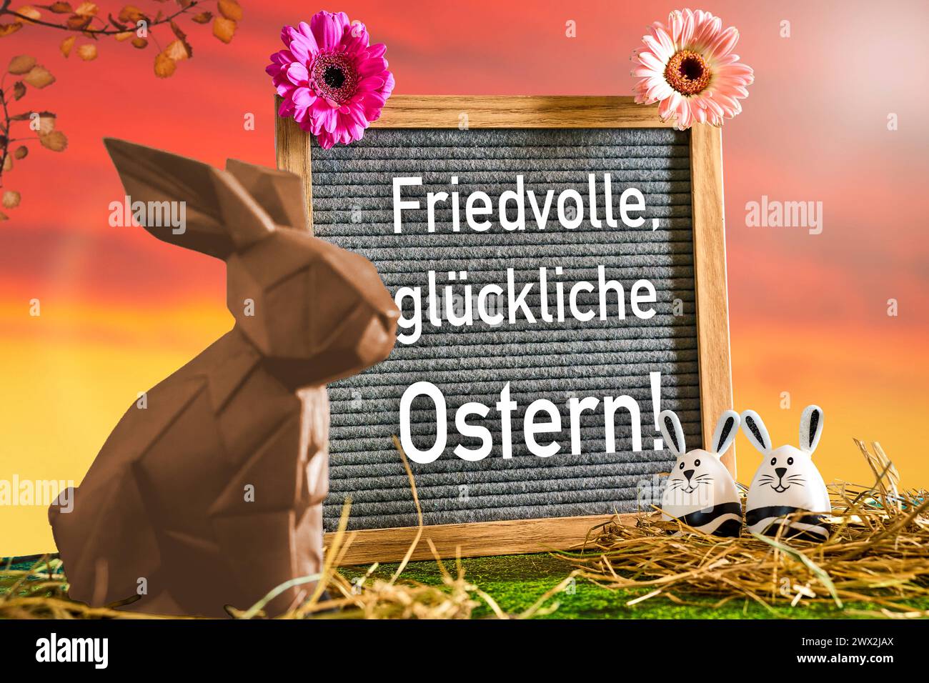 27 March 2024: Peaceful, happy Easter Lettering on a chocolate bar next to a chocolate Easter bunny. PHOTOMONTAGE *** Friedvolle, glückliche Ostern Schriftzug auf einer Tafel neben einem Osterhasen aus Schokolade. FOTOMONTAGE Stock Photo