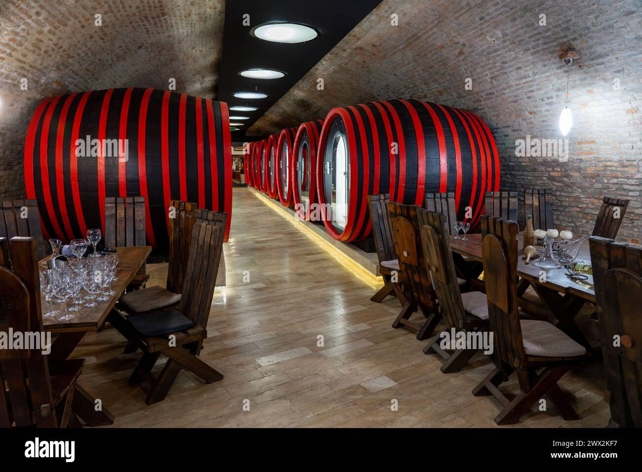 Modern wine cellar in Balatonlelle Hungary with huge wine barrels and wooden tables . Stock Photo